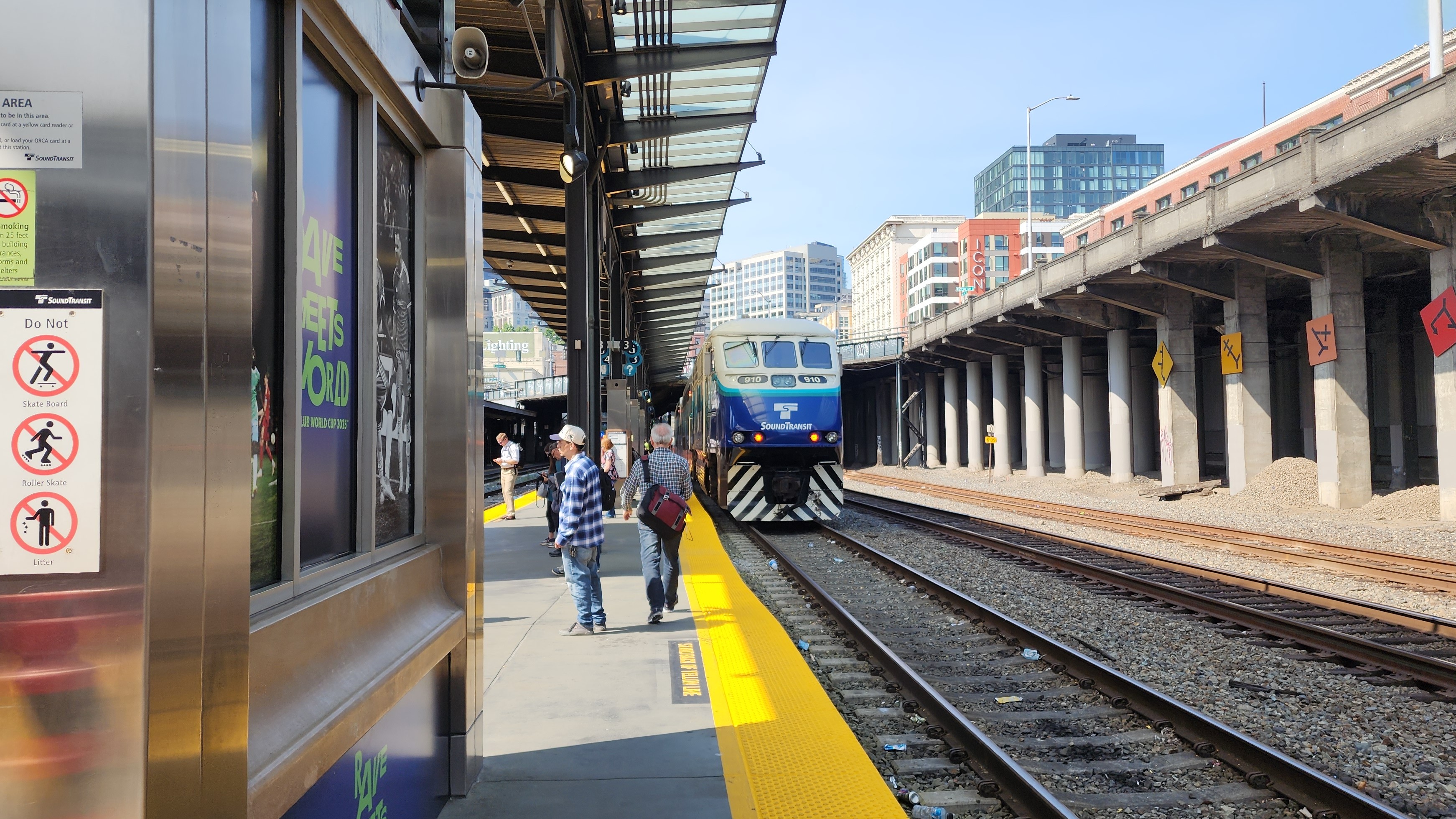 A picture of the Sound Transit Sounder train waiting at King Street Station. There are people lining the platform waiting for a different train. The locomotive can be seen a bit down the platform.